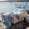 Swans Island Company's Penobscot blankets feature graduated band of white stripes against a ground of hand-dyed color. Made in Maine with soft organic merino wool and American cotton. Organic Ecowash® wool can be gently washed at home. Wedgwood and White