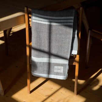 Swans Island Company's Island Throws are made with locally sourced single-origin fleece from a Maine island farm. Shown here, a brown with grey stripes throw.