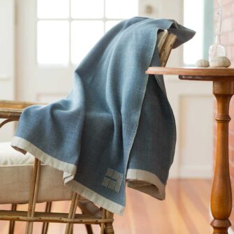 Swans Island Company's Katahdin throw is handwoven in Maine with all natural hand-dyed organic merino wool, Shown here in Marine.