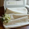 The Swans Island Solstice Throw shown in white + white comes in our distinctive linen presentation gift box. Shown here with a custom date monogram, makes a memorable and very unique wedding gift.