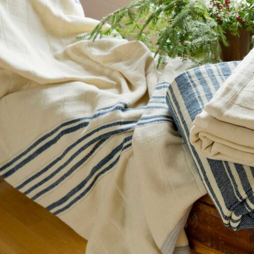 Draped and folded on a bench - Swans Island handwoven Grace Winter Blankets. Shown here in Indigo + Natural and Natural + Indigo.