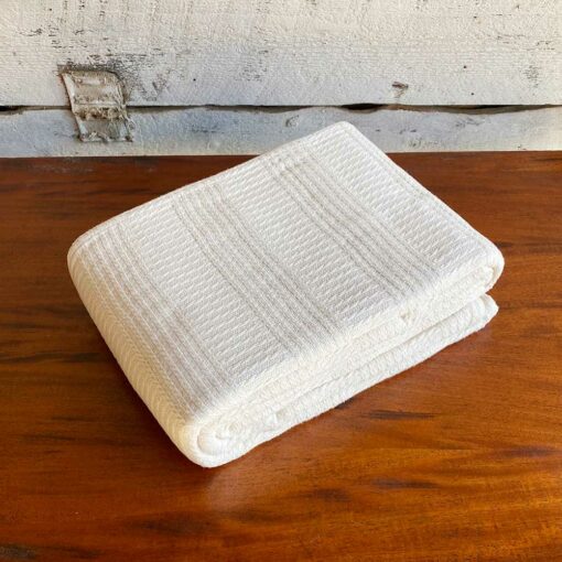 Swans Island Caroline Blanket in undyed natural cotton has a beautiful banded cable texture. Woven in Maine.