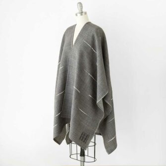 Swans Island's Whitecaps Cape, handwoven in Maine with hand-dyed organic merino wool. Charcoal with Natural colorway.