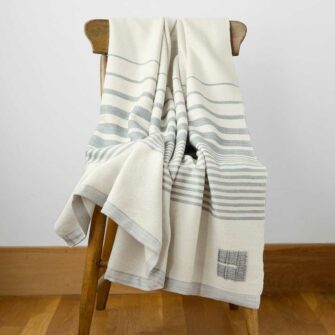 Stillwater Ranch x Swans Island Throw - Ltd. Edition. A collaboration with Chris Pratt and Katherine Schwarzenegger's ranch and Swans Island Co. Kid mohair from Stillwater Ranch is blended with other fine fibers, spun, hand-dyed, handwoven in Maine. Natural with Pewter Stripes.
