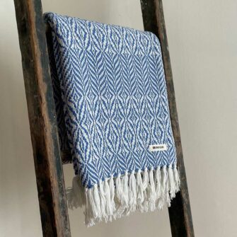 Swans Island's Starburst Throw blanket is woven in Maine with 100% American cotton and features a hand-tied fringe.