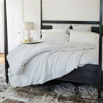 Swans Island Company's Heritage Ticking Linen Bedding. Made in USA of substantial 100% French linen. Duvet cover and shams are shown in Ivory with Graphite ticking stripe paired with Ivory Classic Linen Sheet Set.