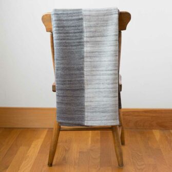 Swans Island's Acadia Patchwork Throw. Upcycled organic merino wool and cotton, made in Maine USA. Graphite/Pewter/Graphite Colorway.