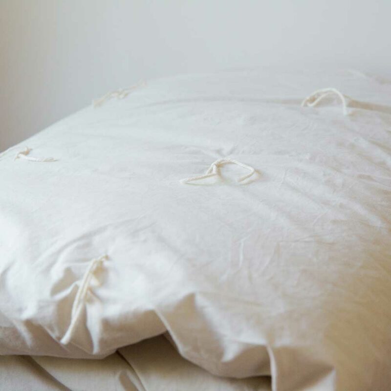 Closeup of American-made 100% wool-filled duvet with cotton cover and hand-tied detail.