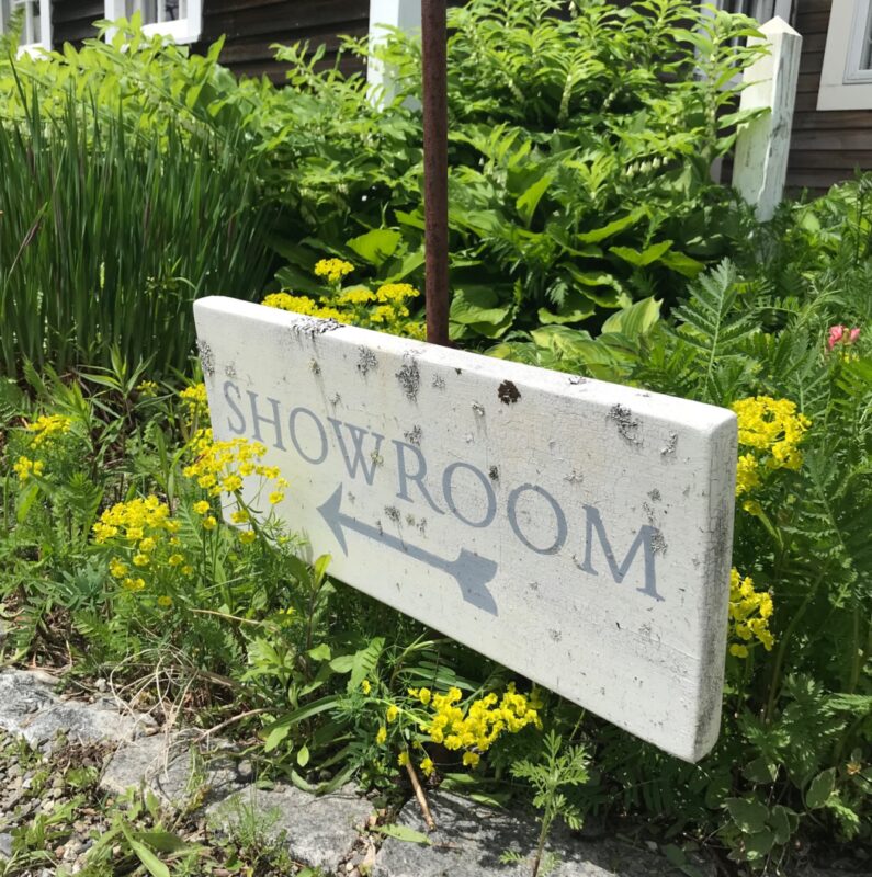 An antique sign points the way toSwans Island Company's Northport Farmhouse.