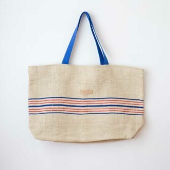 Swans Island Beach Tote by Govou is made from vintage European linen grain sacks. Shown here with red and blue stripes and blue shoulder straps.