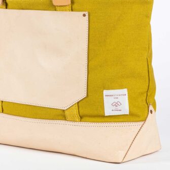 Swans Island Company's Canvas Bucket Tote in heavy cotton canvas with leather bottom and pocket details. - by Immodest Cotton. Chartreuse