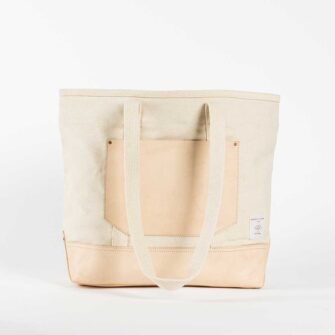 Swans Island Company's Canvas Bucket Tote in heavy cotton canvas with leather bottom and pocket, removable leather handles, and cotton webbing shoulder straps - by Immodest Cotton. Natural