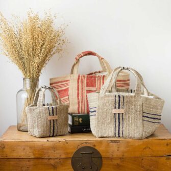 Swans Island's Beach Totes - made by Govou from up-cycled vintage European grain sacks. Shown here in Natural with red and blue stripes in mini a regular sizes.