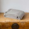 Swans Island Company's Charisma Blanket. Soft 100% Cotton blanket with woven herringbone texture. Made in USA with 100% American cotton. Shown here in Taupe.