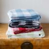 Swans Island Company's Cotton Gingham XL Check Blanket - woven in Maine on antique looms. Made with 100% soft American cotton. Shown here in Blue, Black, Red and Sage.