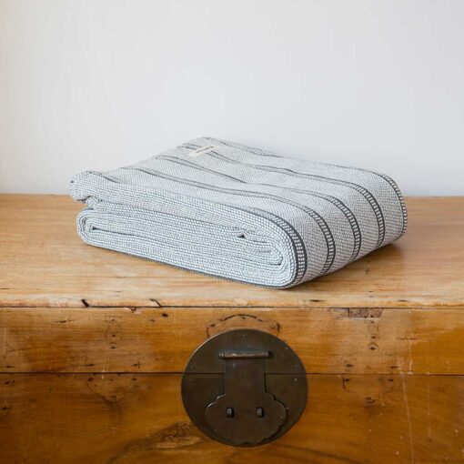 Swans Island Company's Cotton Tulare Blanket. Soft 100% Cotton blanket with yarn-dyed woven stripes. Made in USA with 100% American cotton. Shown here in Medium Charcoal.