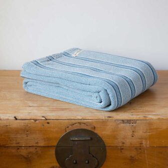Swans Island Company's Cotton Tulare Blanket. Soft 100% Cotton blanket with yarn-dyed woven stripes. Made in USA with 100% American cotton. Shown here in Moonlight Blue.