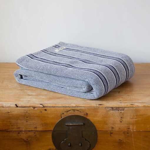 Swans Island Company's Cotton Tulare Blanket. Soft 100% Cotton blanket with yarn-dyed woven stripes. Made in USA with 100% American cotton. Shown here in Navy.