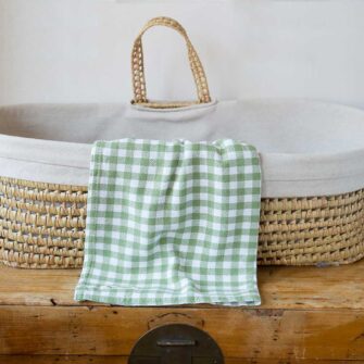 Swans Island Company's Gingham Check Baby Blankets. Woven in Maine with soft American cotton yarns in an assortment of colors. Shown here in Sage and white.