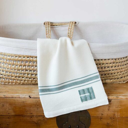 Swans Island Company's classic Grace Baby Blankets. Handwoven in Maine with soft organic merino wool yarns. Pure undyed organic merino wool with an assortment of rich hand-dyed stripe colors. Each blanket comes in a beautiful presentation gift box, perfect for gifting. Shown here in White with Sage stripes.