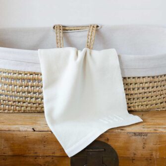Swans Island Company's classic Grace Baby Blankets. Handwoven in Maine with soft organic merino wool yarns. Pure undyed organic merino wool with an assortment of rich hand-dyed stripe colors. Each blanket comes in a beautiful presentation gift box, perfect for gifting. Shown here in Solid White.