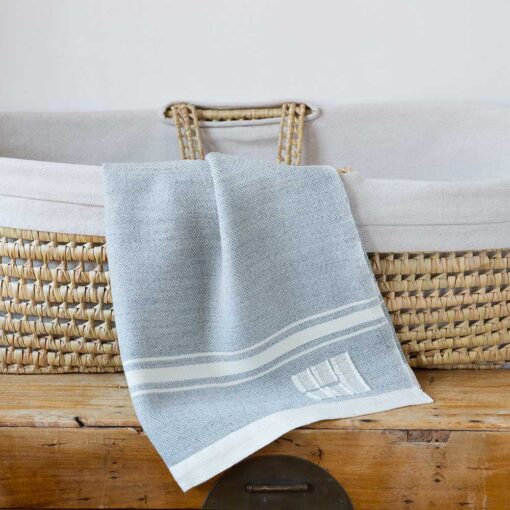 Swans Island Company's Modern Grace Baby Blankets. Handwoven in Maine with soft organic merino wool yarns in an assortment of rich hand-dyed colors. Each blanket comes in a beautiful presentation gift box, perfect for gifting. Shown here in Seasmoke with natural stripes.