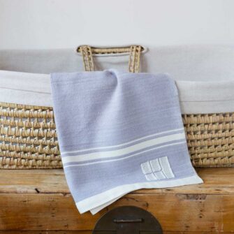Swans Island Company's Modern Grace Baby Blankets. Handwoven in Maine with soft organic merino wool yarns in an assortment of rich hand-dyed colors. Each blanket comes in a beautiful presentation gift box, perfect for gifting. Shown here in Dusk with natural stripes.